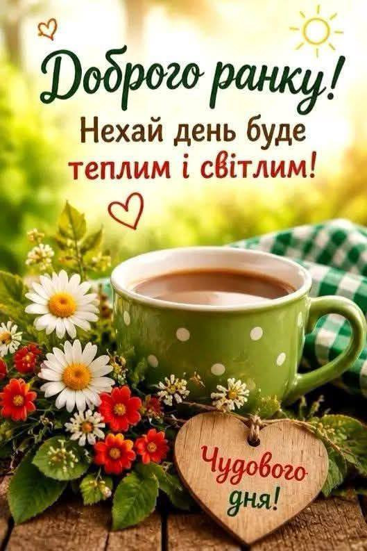 Зелена чашка кави на столі поруч із букетом ромашок та дерев